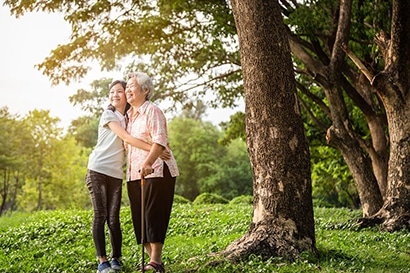 A child hugs her grandmother as they spend time outdoors.